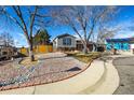 House exterior with gray siding, rock landscaping, and wood fence at 16357 E Wyoming Dr, Aurora, CO 80017