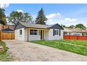 Quaint home with a gravel driveway and fresh green lawn at 851 S Eliot St, Denver, CO 80219