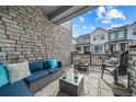 Cozy porch featuring a stone wall, comfortable seating, and a view of the neighborhood at 7484 W Atlantic Ln, Denver, CO 80227