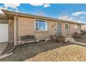 Close up of brick home exterior with bench, trimmed bushes, and a security door at 6581 S Logan St, Centennial, CO 80121