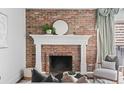 Close-up of the living room fireplace with a brick surround and decorative mantle at 700 N Washington St # 502, Denver, CO 80203