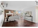 Spacious living room featuring hardwood floors, a brick fireplace, and natural light from the balcony at 700 N Washington St # 502, Denver, CO 80203
