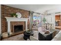 Bright living room with a brick fireplace, balcony access, and a modern chandelier at 700 N Washington St # 502, Denver, CO 80203
