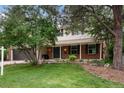 Charming two-story home with landscaped yard and a brick facade on a sunny day at 8666 E Easter Ave, Centennial, CO 80112