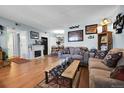 Comfortable living room featuring stylish furnishings, a fireplace, and hardwood flooring for a warm aesthetic at 3550 S Harlan St # 174, Denver, CO 80235