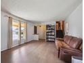 Inviting living room with hardwood floors, large windows, and access to the staircase at 3625 E 128Th Pl, Thornton, CO 80241