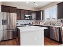Modern kitchen featuring stainless steel appliances, dark cabinets, and stylish backsplash at 9084 Ellis Way, Arvada, CO 80005