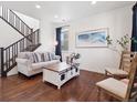 Bright living room with hardwood floors, staircase, stylish furnishings, and a large framed art piece at 9084 Ellis Way, Arvada, CO 80005