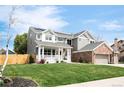 Beautiful two-story home with a welcoming front porch and a lush green lawn, enhanced by solar panels at 5962 S Sheridan Way, Littleton, CO 80123