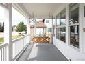 Inviting porch with a charming wooden swing and sun-drenched windows overlooking the neighborhood at 5962 S Sheridan Way, Littleton, CO 80123