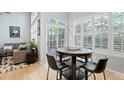 Bright breakfast nook with light hardwood floors, large windows, and sliding glass doors to a private patio at 1355 S Ulster St, Denver, CO 80231