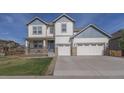 Charming two-story house with a welcoming front porch and a spacious three-car garage at 404 Dusk Ct, Erie, CO 80516