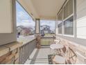 Cozy covered porch with stone accents, seating area, and view of the neighborhood street at 404 Dusk Ct, Erie, CO 80516