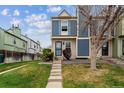 Inviting townhouse featuring blue accents, complemented by a green lawn and concrete steps at 1612 S Idalia Cir # A, Aurora, CO 80017