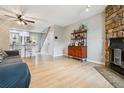 Open living room and kitchen area featuring a cozy fireplace, wood floors, and open floor plan to the kitchen at 1612 S Idalia Cir # A, Aurora, CO 80017