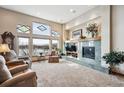 Spacious living room featuring high ceilings, fireplace, and large picture windows at 7700 W Grand Ave, Littleton, CO 80123