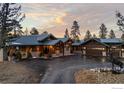 Impressive single-Gathering home with mature landscaping, dark metal roof, and welcoming driveway at 4446 Songbird Ln, Evergreen, CO 80439