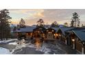 Exterior of home featuring professional landscaping, mountain views, and circular driveway at 4446 Songbird Ln, Evergreen, CO 80439