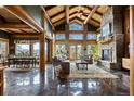 Bright, open-concept living room with wood beams, stone fireplace and mountain views at 4446 Songbird Ln, Evergreen, CO 80439