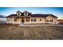 Inviting two-story home features dormer windows, a covered porch, and meticulous gravel landscaping at 4820 S County Road 137, Bennett, CO 80102