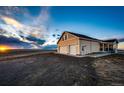 Exterior view featuring an attached two-car garage, a well-lit exterior, and ample parking at 4820 S County Road 137, Bennett, CO 80102