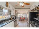 Traditional kitchen with tile floors, white cabinets, stainless steel appliances, and bright natural light at 3439 Burnham Dr, Kittredge, CO 80457