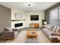 Bright living room features a fireplace, wood floors, modern lighting, and a comfortable seating arrangement at 228 N Edge Cliff St, Castle Rock, CO 80104