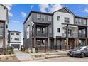 Modern townhome showcasing a contemporary design, a fenced yard, and a private balcony on the second floor at 6834 Merseyside Ln, Castle Pines, CO 80108