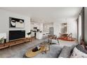 Open-concept living area with modern furniture and decor flowing into the bright kitchen and dining space at 17847 Dandy Brush Dr, Parker, CO 80134