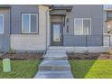 Modern front entrance with gray siding, brick accents, and concrete steps at 1242 S Algonquian, Aurora, CO 80018