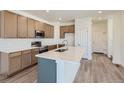 Modern kitchen with light wood cabinets, quartz countertops, and stainless steel appliances at 1242 S Algonquian, Aurora, CO 80018