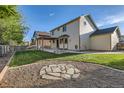 Spacious backyard featuring a well-maintained lawn, a fire pit, and a pergola-covered patio at 13018 Niagara Way, Thornton, CO 80602