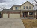 Well-maintained two-story home with brick and tan exterior, spacious driveway, and inviting front porch at 13018 Niagara Way, Thornton, CO 80602