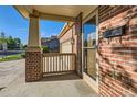A view of the front porch and the home's brick facade at 13018 Niagara Way, Thornton, CO 80602