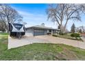 A lovely house with a driveway, trees, and well-maintained exterior creates an inviting curb appeal at 415 Lamar St, Lakewood, CO 80226