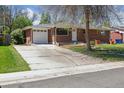 Well-maintained brick home with a driveway, manicured lawn, and attached garage at 269 Beryl Way, Broomfield, CO 80020