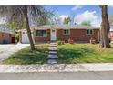 Brick ranch style home with green lawn, front garden and mature trees at 269 Beryl Way, Broomfield, CO 80020