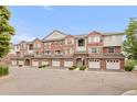 Charming townhouse featuring red brick, individual garages, and well-maintained landscaping at 8944 Fox Dr # 203, Thornton, CO 80260