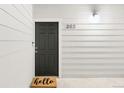 Close-up of a black front door with the unit number 203 on a white shiplap wall at 8944 Fox Dr # 203, Thornton, CO 80260