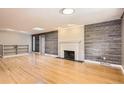 Spacious living room featuring hardwood floors, a fireplace, and wood paneling accent wall at 3480 S Dayton St, Denver, CO 80231