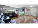 Cozy living room featuring hardwood floors, a comfortable leather sofa, and abundant natural light at 1818 South Union Ct, Lakewood, CO 80228