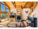 Inviting living room with stone fireplace, wooden ceilings and grand piano at 10450 Hondah Dr, Littleton, CO 80127