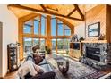 Stunning living room with vaulted wood ceilings, stone fireplace, and mountain views at 10450 Hondah Dr, Littleton, CO 80127