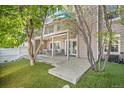 View of backyard featuring a covered deck, outdoor seating, manicured lawn, mature trees, and privacy fence at 9875 Greensview Cir, Lone Tree, CO 80124