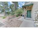 Charming entrance with a green door surrounded by professionally landscaped yard and a short stepped walkway at 31112 Black Eagle Dr # 101, Evergreen, CO 80439