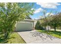 View of a two car garage and driveway of a home with mature shade trees at 19804 E Villanova Pl, Aurora, CO 80013