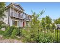 Exterior view of charming townhomes with balconies, set behind a black metal fence at 4728 S Acoma St, Englewood, CO 80110