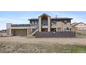 Two-story house with a deck over the garage, stairs to entry, and a fenced yard at 59 S De Gaulle St, Aurora, CO 80018