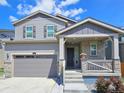 Inviting home featuring stone accents, a covered porch, and a well-maintained front yard at 656 N Bersshine St, Watkins, CO 80137
