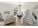 Bright, open living room with soaring ceilings, dining area, and modern staircase at 2089 Meadow Sweet Ln, Erie, CO 80516